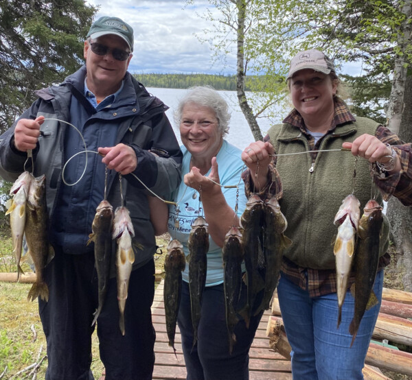 fish2 A family holding a freshly caught string of fish at Woman Lake Lodge
