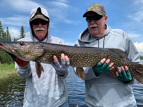 IMG_0666-web 2 men hold a freshly caught fish at Woman Lake Lodge